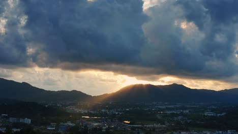 4k aerial drone top view of sunset over town and hill. beautiful sunset back of hill with sun ray. sunset over town shot from drone.