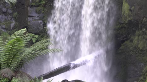 Close-up-of-bottom-waterfall-flowing-into-river-stream-onto-log