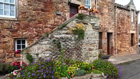 stone building with vibrant flowers in crail