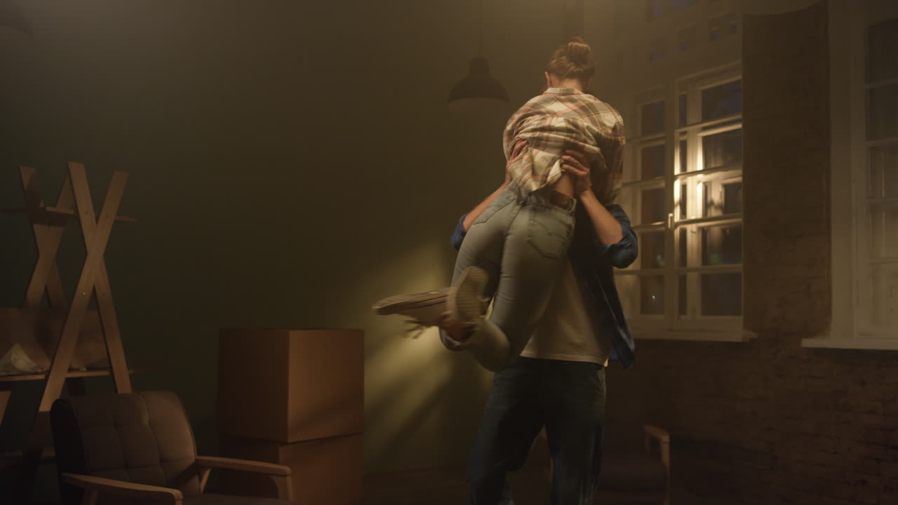 una pareja feliz abrazada en una casa renovada, un hombre en ascenso, una mujer en un nuevo apartamento.