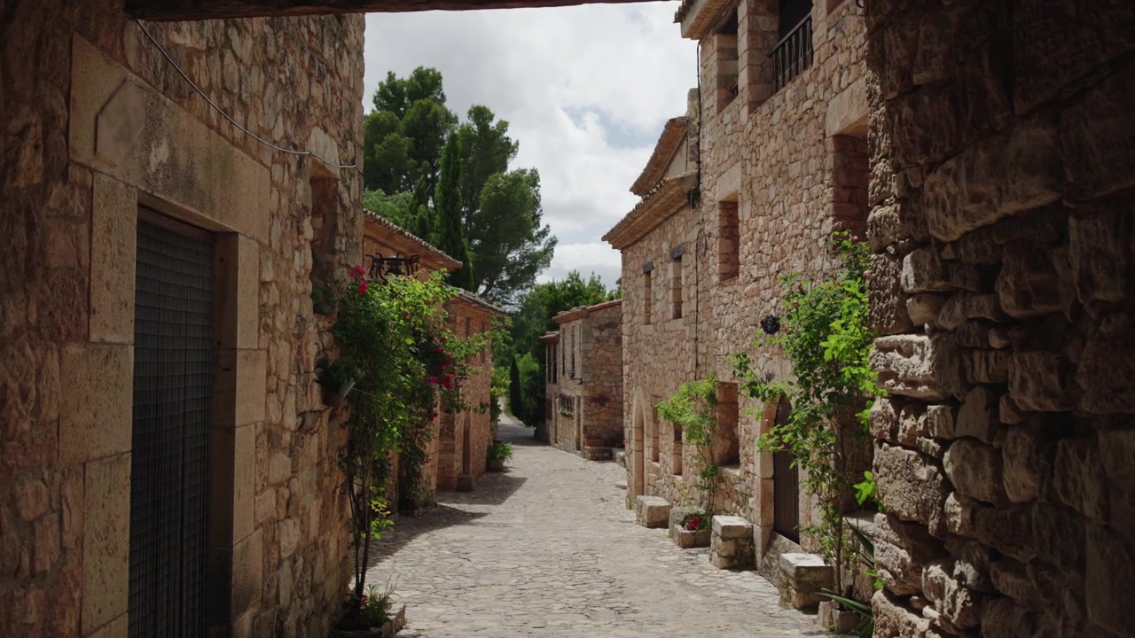 Vicolo in pietra nello storico villaggio di Siurana con case medievali e strada acciottolata, Catalogna, Spagna. Architettura tradizionale, facciate in pietra rustica e atmosfera tranquilla di un borgo montano conservato.