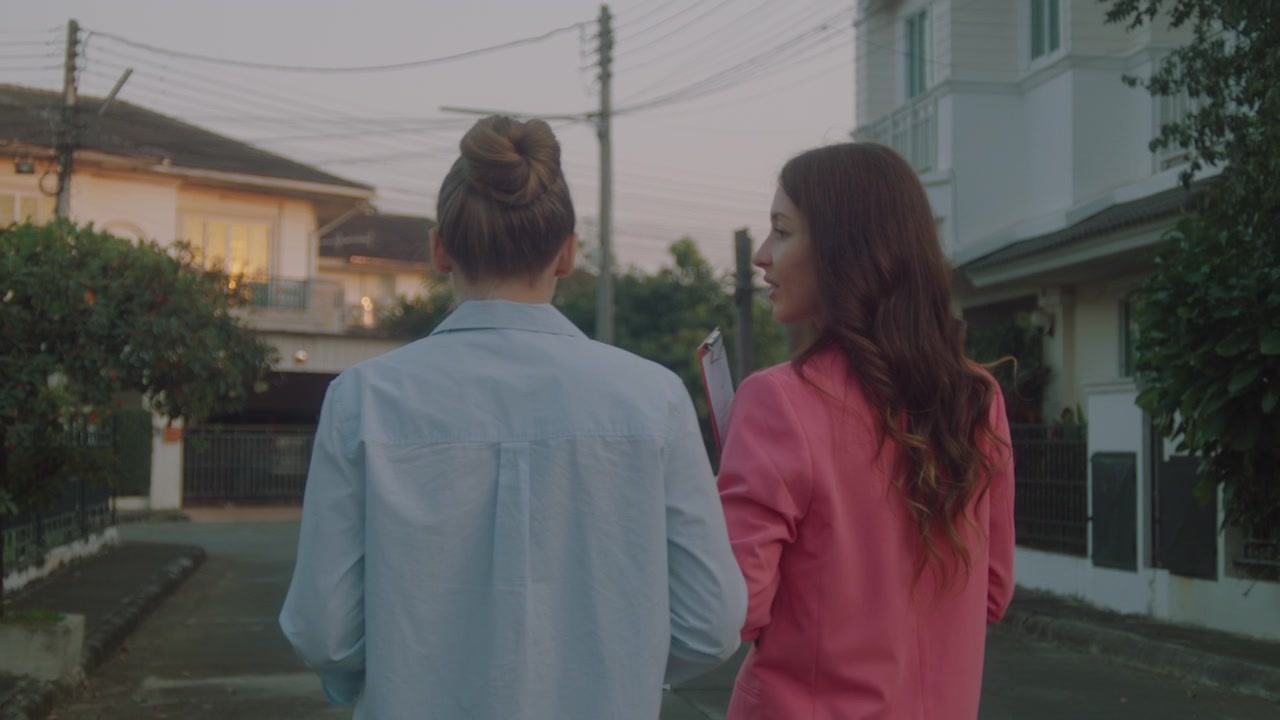 Real Estate Agent Showing Property to Potential Buyer in Residential Neighborhood