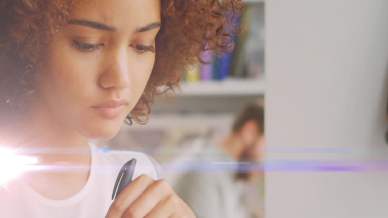 Animation of light spots over biracial woman with pen