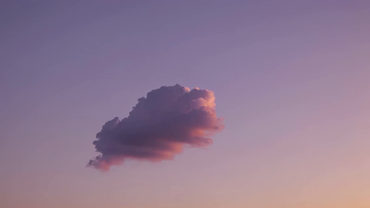 A single cloud floats in a pastel sky at sunset, captured from a low-angle, creating a serene