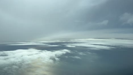 pov cloudscape shot from an airplane flying across a clouded sky over the sea in a cold winter afternoon