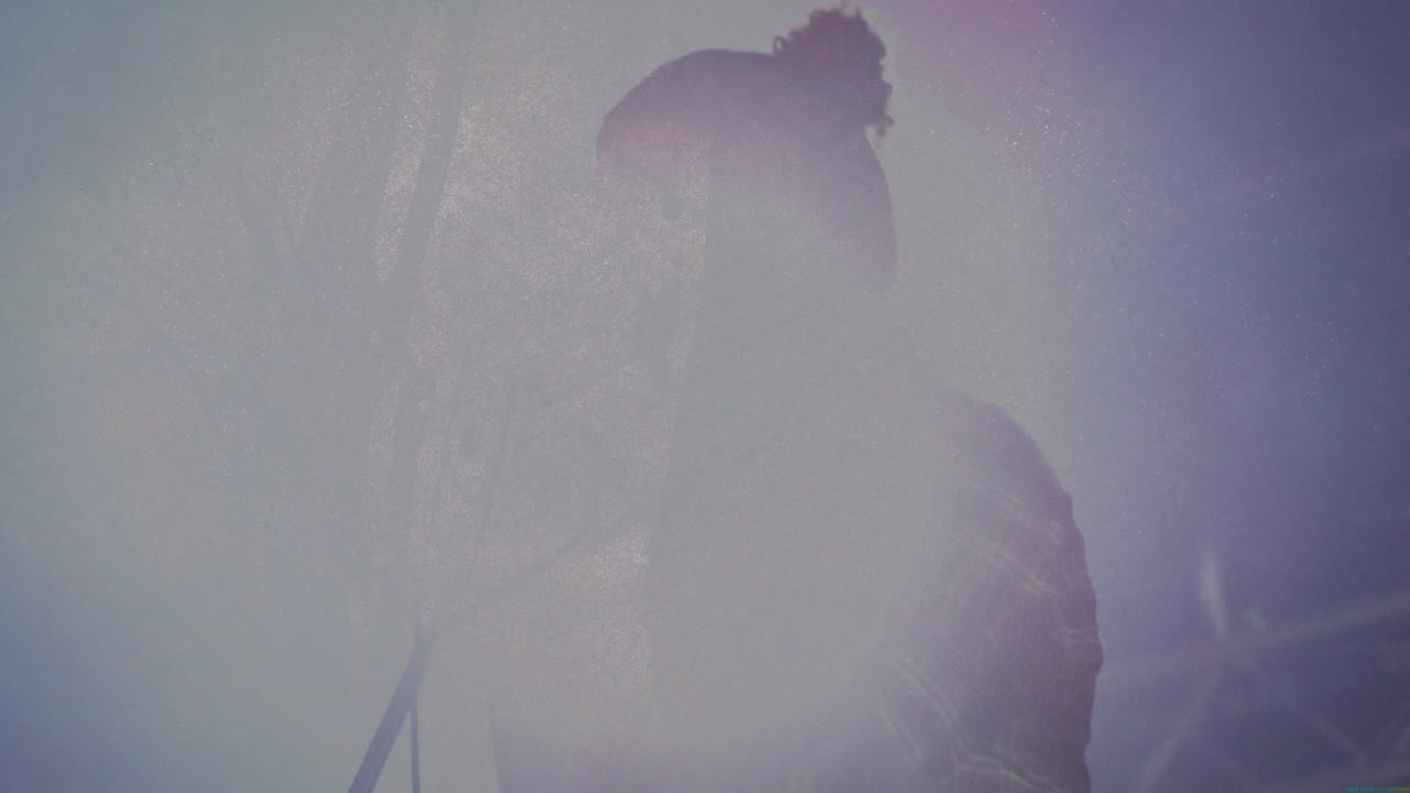 music industry male singer performing concert, with animated soundwave graphics over lens flare