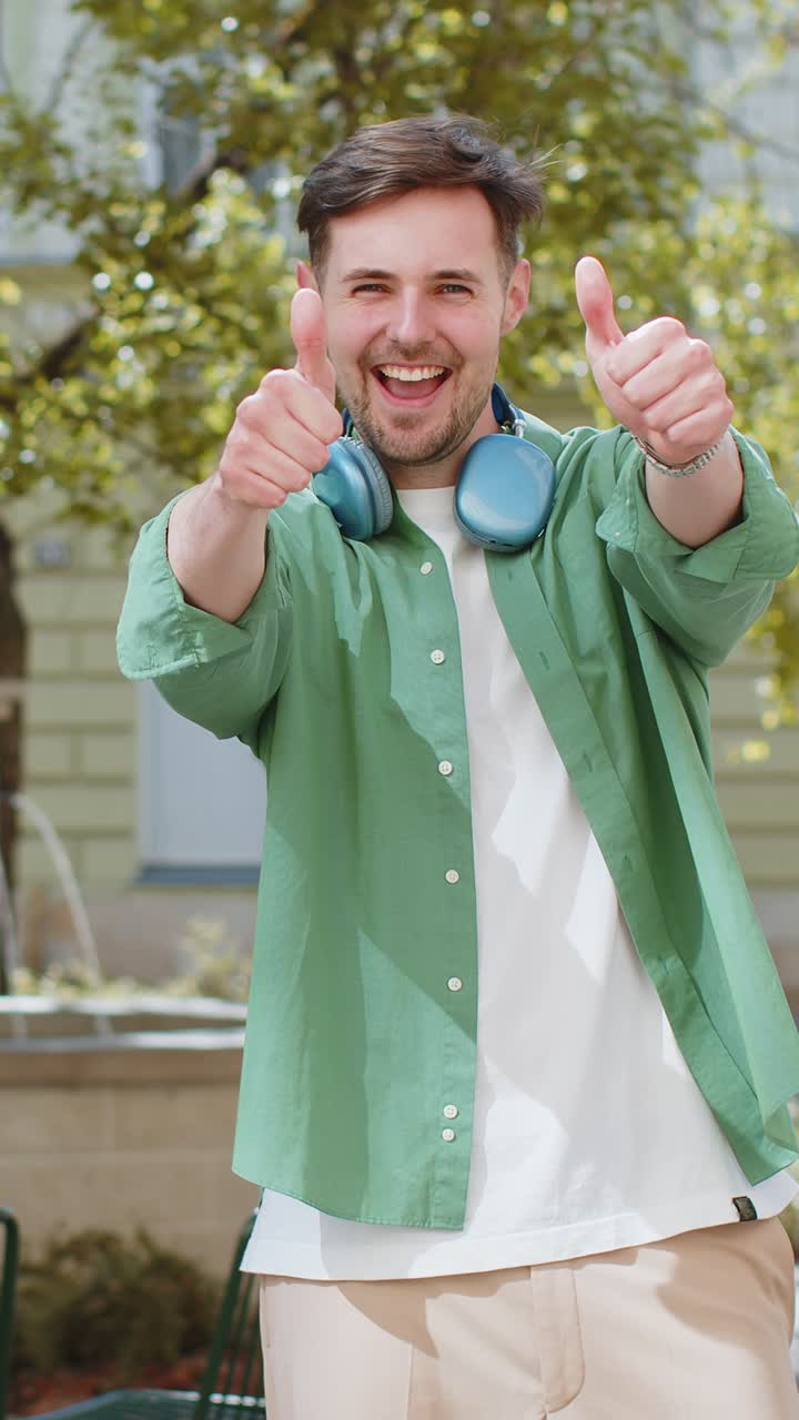 uomo felice turista che mostra il pollice in alto come positivo qualcosa di buono feedback positivo sulla strada della città