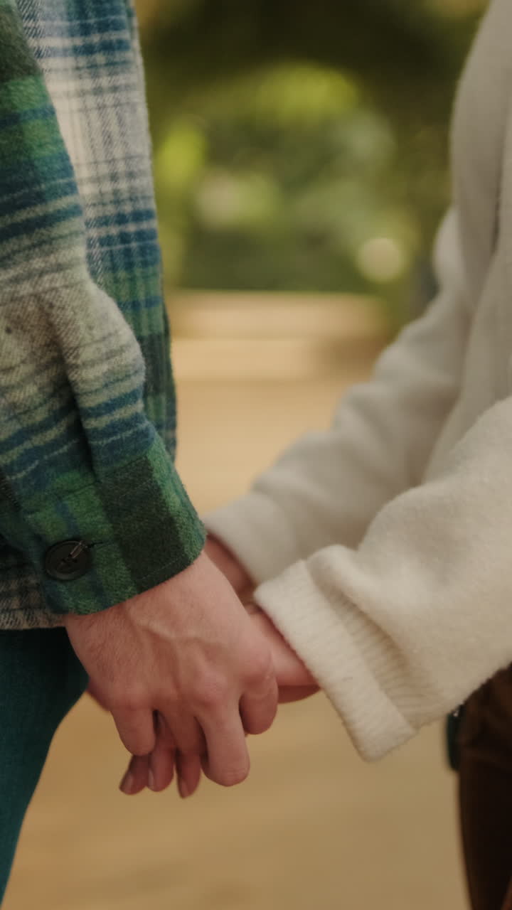 Young couple holding hands, close-up of hands