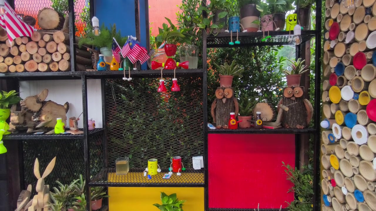 Handcrafted wooden animal sculpture displayed in an indoor garden. Detailed timber artwork set among lush indoor landscaping plants and tropical foliage. Elegant green interior decoration.