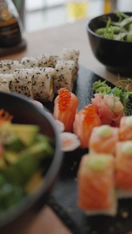 vertical zoom on nigiri sushi red caviar detail with served maki rolls, denmark