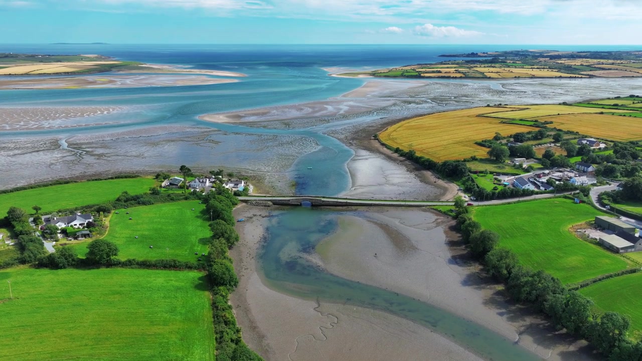 Wexford İrlanda Destansı Konumlar: Yazın gelgitin çekildiği zamanda Saltmills'deki köprü üzerinden Bannow Koyu Lagünü'ne doğru uçan drone.