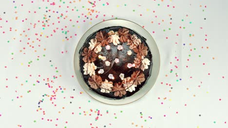 vista superior de un mostrador donde un pastel de cumpleaños es puesto por manos femeninas