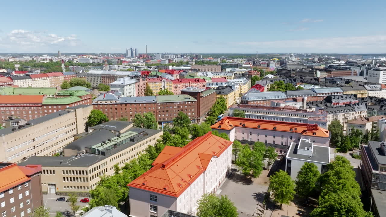 Aerial view rotating over buildings and streets of Toolo, sunny day in Helsinki