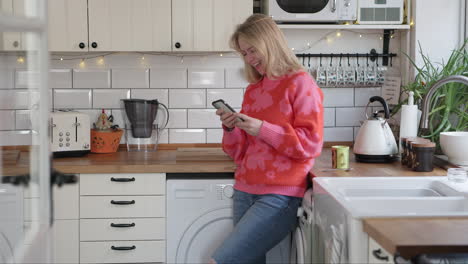 a woman in a kitchen using her phone