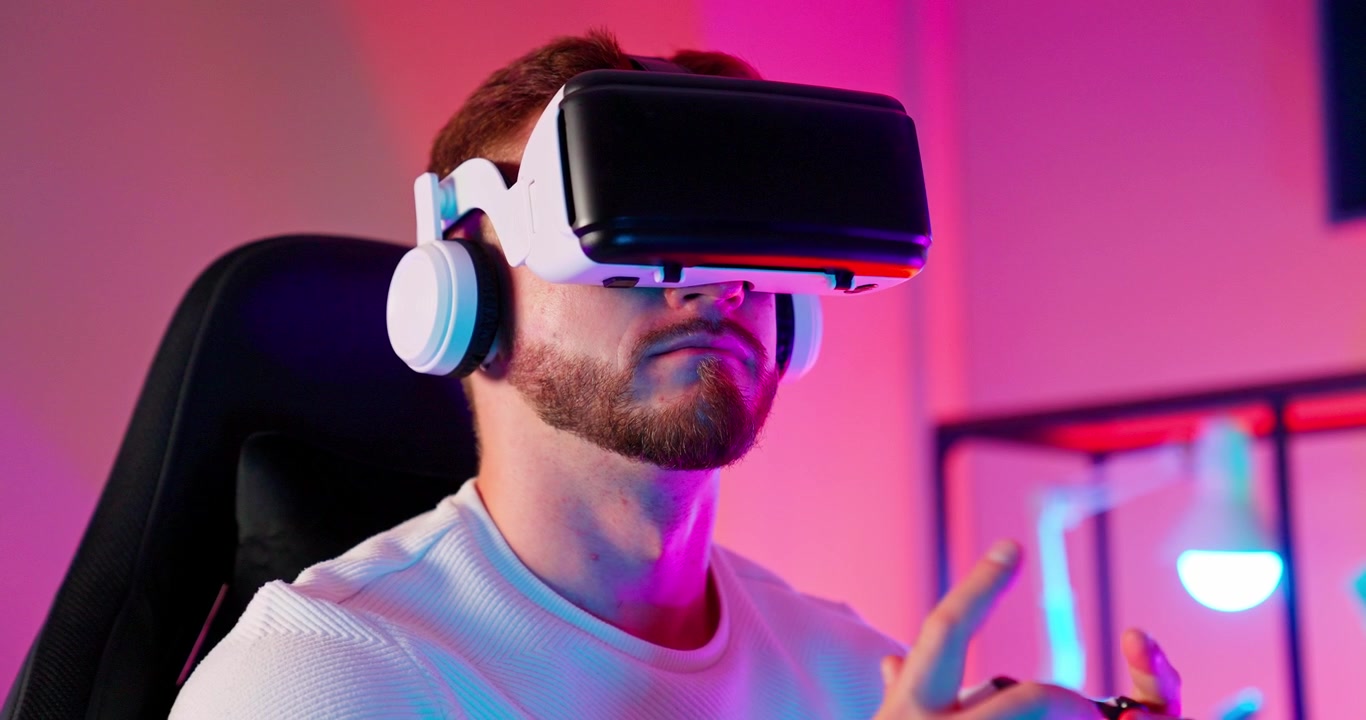 Uomo con visore VR e cuffie in una stanza illuminata al neon