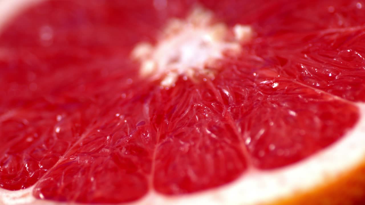 Con metà di un pompelmo fresco da cui gocciola una goccia di succo