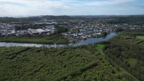 industrial buildings and houses with vegetation along currumbin creek in queensland, australia