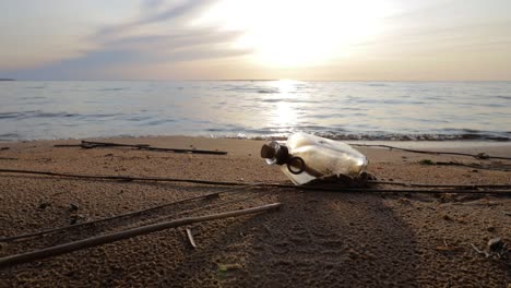 Message-in-the-bottle-against-the-Sun-setting-down