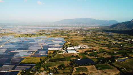 aerial landscape vietnam agricultural saline farm, seawater evaporation for salt extraction, windmill turbine at distance