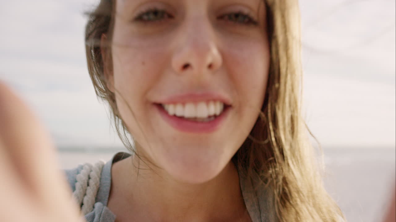 hermosa mujer tomando una selfie usando el teléfono en la playa al atardecer sonriendo y girando disfrutando de la naturaleza y el estilo de vida en vacaciones