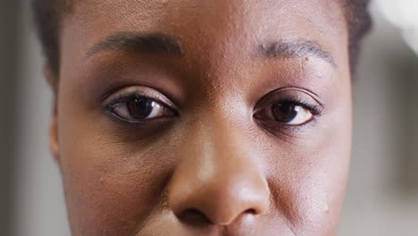 Video-close-up-portrait-of-the-opening,-blinking-eyes-of-african-american-female-doctor