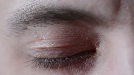 close up 4k footage of a mans eye opening, closing and looking around