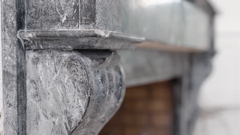 slow descending bokeh shot of an antique stone fireplace facade within a villa