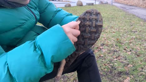 close-up shot of a boy cleaning his hiking boots after a long hike