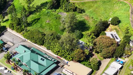 aerial footage captures a lush green landscape with buildings, showcasing vibrant greenery and architectural structures under bright daylight