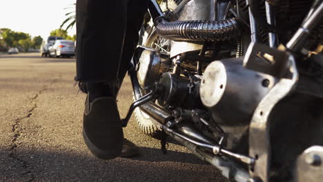 struggling to kick start a motorcycle on the roads of california