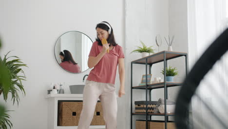woman dancing and singing in a bathroom