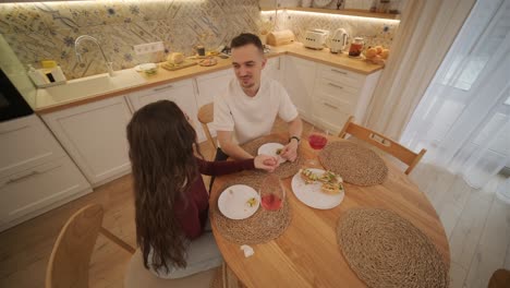 una pareja enamorada haciendo un sándwich en la cocina de la sala de estar