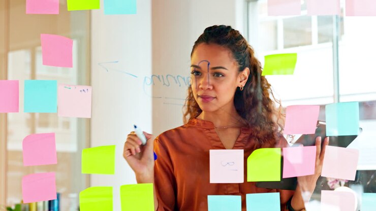 A female designer planning ideas on a glass wall