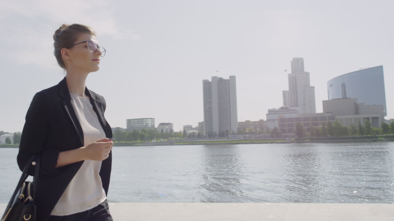 Confident Business Woman Walking Along River