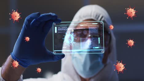 animation of orange virus cells over caucasian male lab worker in safety clothes with digital card