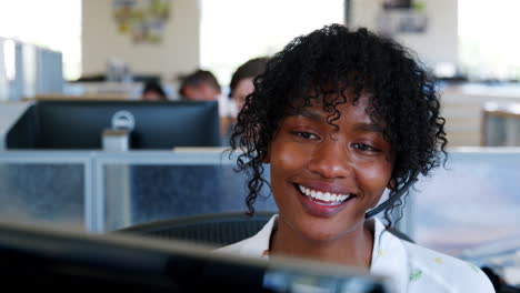 young black woman using computer in a call centre, close up