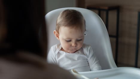 Video-De-Mamá-Alimentando-A-Su-Bebé-En-Una-Silla-Alta.