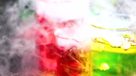 vibrant liquids reacting with smoke in beakers