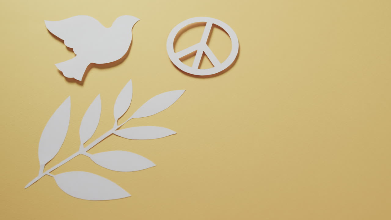 primer plano de una paloma blanca con un signo de paz y una hoja y un espacio de copia en fondo amarillo