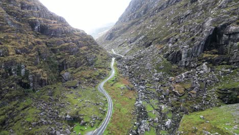 cinematic drone footage gap of dunloe ireland, aerial footage moving through the rock cliff walls