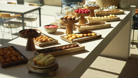 disfrutar de una lujosa mesa de pastelería en un hotel brunch con pasteles glamurosos y croissants hermosamente iluminados por el sol