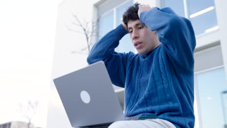 Shocked young man using netbook in city