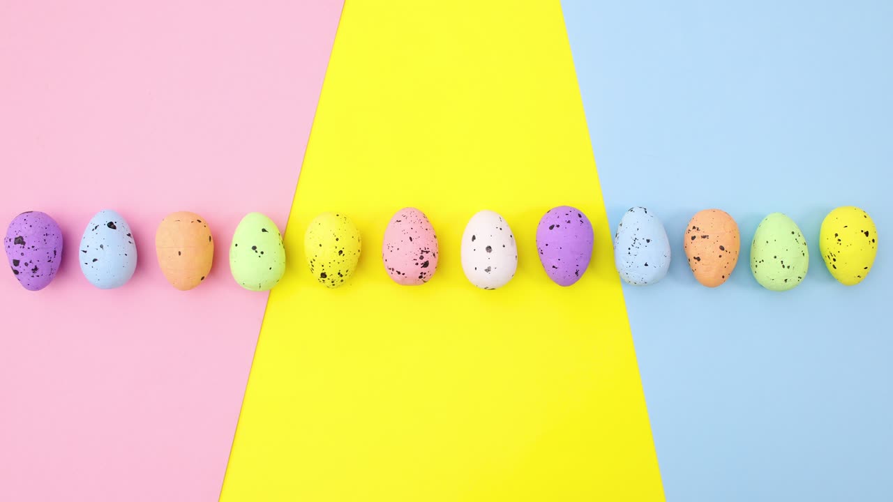 Huevos de Pascua coloridos se mueven uno por uno sobre un tema colorido. Stop motion.
