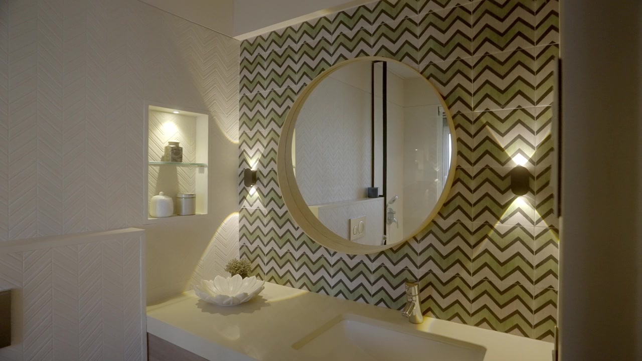 Interno bagno con specchio rotondo montato su parete dal design astratto. Inquadratura di rivelazione.