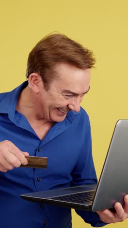 man shopping online with a credit card and laptop