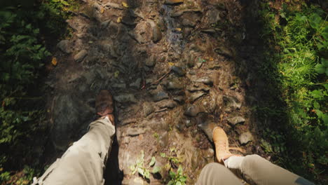 A Couple Of Tourists Are Walking Along A Slippery Stony Path First-Person View Hiking And Active Res