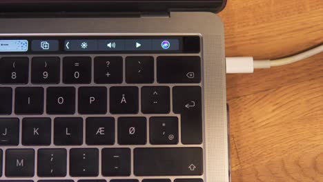 finger unlocking a macbook pro via the biometric fingerprint scanner