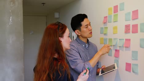 business executives discussing over sticky notes