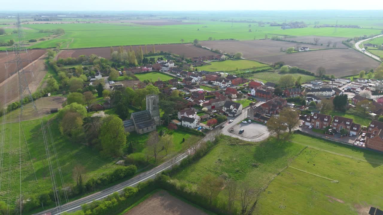 Aerial drone view of small scenic village in England UK on sunny afternoon green rural fields