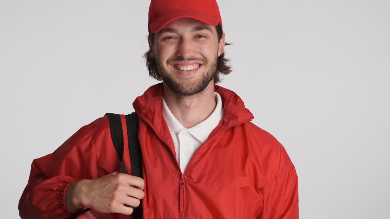 el repartidor caucásico frente a la cámara sobre un fondo blanco.